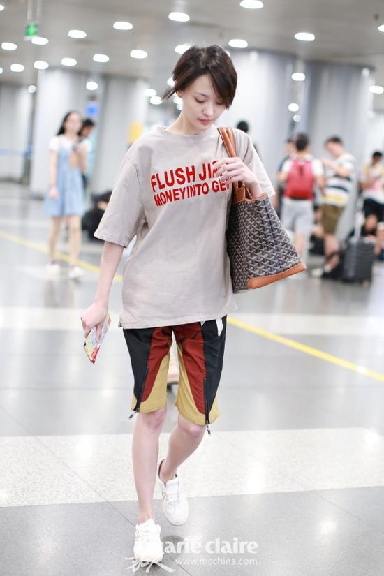 郑爽机场街拍。她身穿浅咖啡色字母印花T恤,肩背Goyard印花托特包,下穿Louis Vuitton拼色短裤,脚踩飞跃牌白色球鞋。